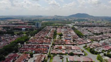 Top Aerial View Of Housing And City In Malaysia With Beautiful Mountain Views and Trees
