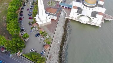 Top Aerial View Of People And Cars In Front Of The Beautiful White Mosque Beside The Sea