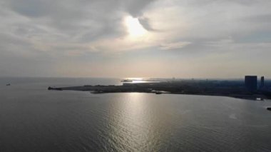 Bulutlar ve deniz manzaraları arasında güneş ışığı olan güzel gökyüzü manzarası soldan sağa dolly..