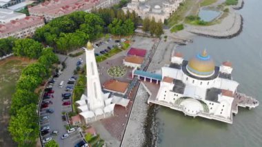 Top Aerial View Of People And Cars In Front Of The Beautiful White Mosque Beside The Sea