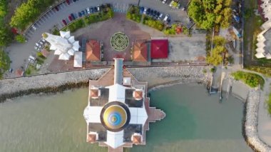 Deniz kenarındaki güzel beyaz cami çatısı, küçük dalgalar ve araba parkı, statik dönüşümlü.