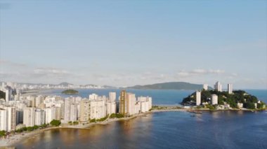 Santos şehri ve dağıyla denize yakın yeşil bir adada gökdelen manzarası var.