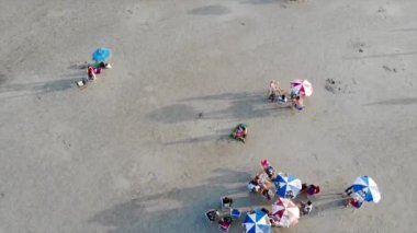 Sahilde renkli şemsiyeli insanların en iyi görüntüsü.