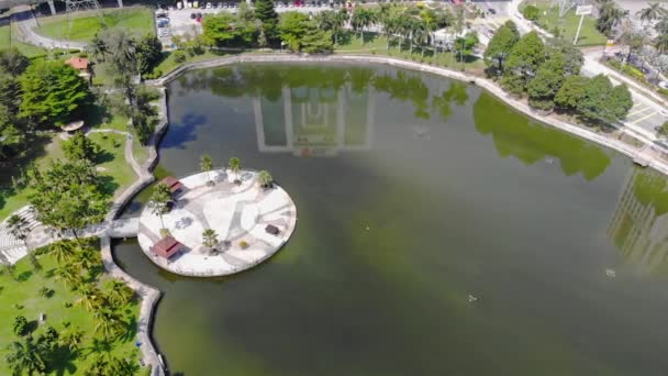 Top Aerial View Green Lake Roundabouts Reflections Buildings Dolly Right — Stockvideo
