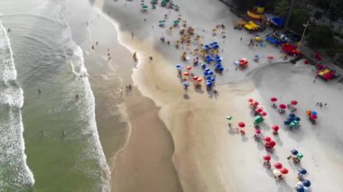 Sahilde güneş banyosu yapan ve dalgalarla oynayan insanların en iyi görüntüsü.