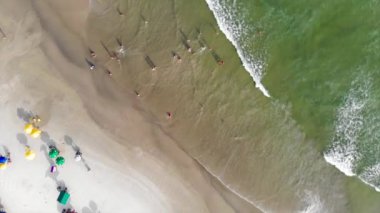 Guaraju Sahili 'nde oynayan ve yüzen bir sürü insan var.