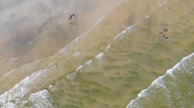 Sahilde dalgalarla oynayan insanların en iyi görüntüsü