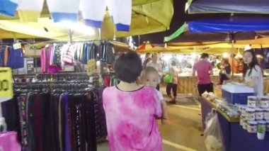  Anne ve bebeği gece pazarında yürüyorlar..