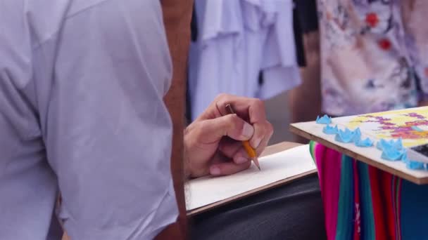 Άνθρωποι Που Ζωγραφίζουν Στο Μικρό Βιβλίο Χέρι Που Πραγματοποιήθηκε — Αρχείο Βίντεο