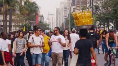 Abur cubur satıcısı, mallarını kafasıyla insanların arasında taşıyor. 