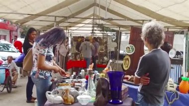 Yol kenarındaki küçük bir dükkanda küçük bir cüzdana bakan kadınlar..