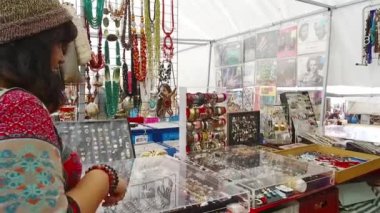  Bir kadın yol kenarındaki küçük bir dükkanda güzel aksesuarlara bakıyor..