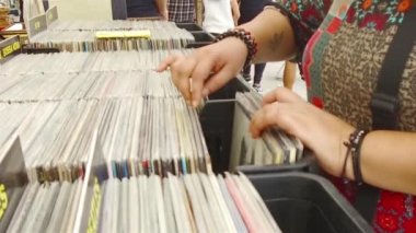 Bir kadın renkli kitaplarla dolu rafta kitaplara bakıyor.