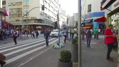  Siyah tişörtlü kadın çantasıyla sağdan sola doğru yürüyor..