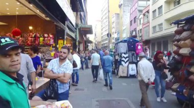 Kaldırımlar yayalarla dolu ve dükkanlar arasında el ele tutuşmuş.