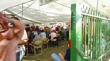 İnsanlar yemek yiyor ve yemek standında kuyruğa giriyorlar..