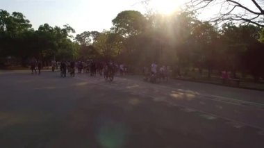 İnsanlar parkta bisiklete biniyor ve birlikte yürüyor.