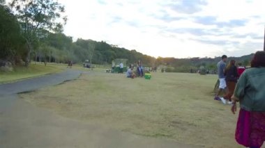 Sahada bir kayanın üstünde oturan romantik bir çift, tepe manzaralı...