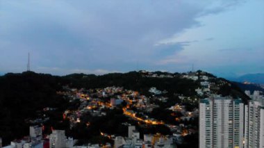  Dağlardaki ev ışıklarının ön hava manzarası Crane Up.