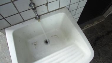 Su Musluğu ile Kirli Beyaz Lavabo.