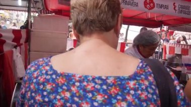 Gıda standında yemek yiyen bir grup insan.