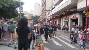 Siyah gömlekli kıvırcık saçlı adam yolun kenarında dikiliyor..