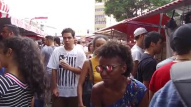 : İnsanlar şehrin göbeğindeki bir lokantada yürüyor ve yemek yiyorlar.