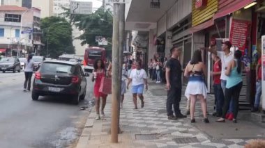 : Kırmızı Tişörtlü Kadın Kırmızı Çanta Taşırken Yürüyor