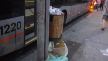 Turuncu şehir otobüsleri yolcuları otobüs durağından alıyor.