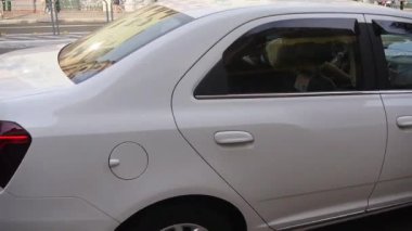 Yolun kenarındaki beyaz giysili araba.