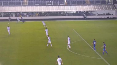 Gece mavi beyaz futbol takımı yeşil sahada oynuyor.