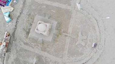  İnsanlar şemsiyeler ve küçük kum binaları altında güneşleniyor.
