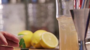 Adding Ice To Yellow Liquid - Close Up.