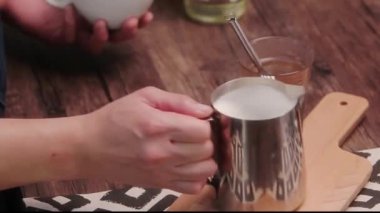 Eller sütü demir bir bardağa çeviriyor.