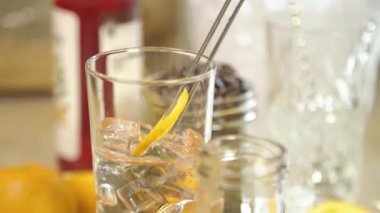 Add Orange Slices Then Ice To Syrup In Glass - Close Up.