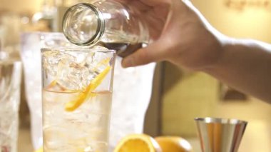 Adding Black Water To Ice Water In A Glass - Close Up