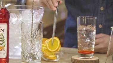 Adding Orange Slices to Ice Water in a Glass