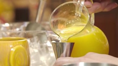 Pouring Yellow Juice Into a Shaker With Jigger - Close Up