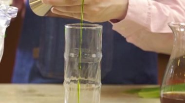 Pour Green Syrup Into a Glass With Jigger.
