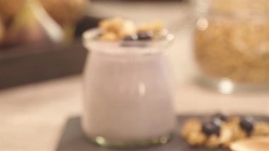 a glass of yogurt next to blueberry - slide right in