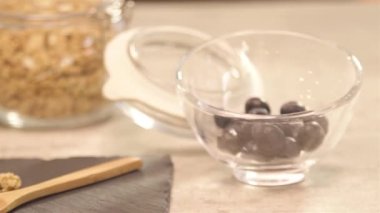 a glass of yogurt next to blueberry - slide left.