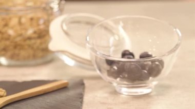 a glass of blueberry next to yogurt - slide left.