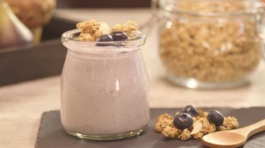 a glass of yogurt next to blueberry - static - dolly backward