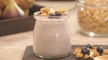 a glass of yogurt on the napkin with blueberry - Rack focus in.