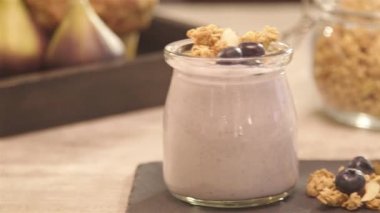 a glass of yogurt with granola and blueberry - slide left.
