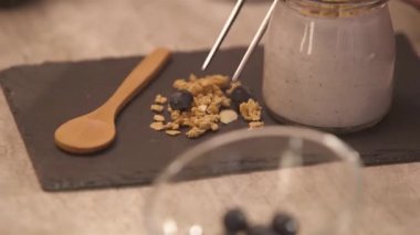 Blueberry put on the top of the granola - rack focus.
