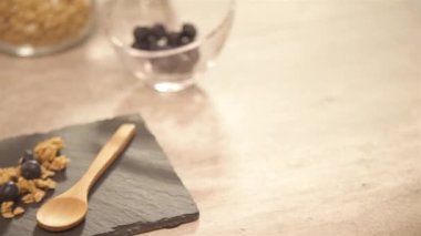 Jars and muffin on the table with yogurt - pan left.