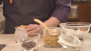 Man pick up blueberry with tong to jar - panning
