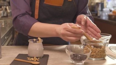 Man putting gronola from the jar on napkin - static
