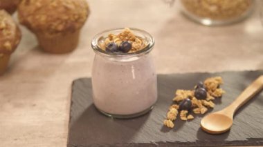 Bir bardakta yoğurt, masada muffinler - solda tava